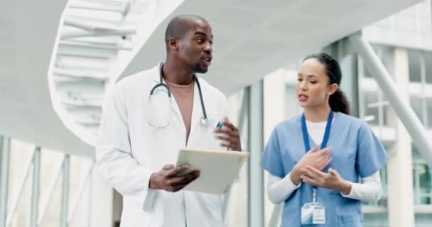 Talking, walking and doctors with a tablet, teamwork and digital planning with diagnosis, results and website information. Medical professionals, black man and woman in a hospital with a strategy. - Footage, Video