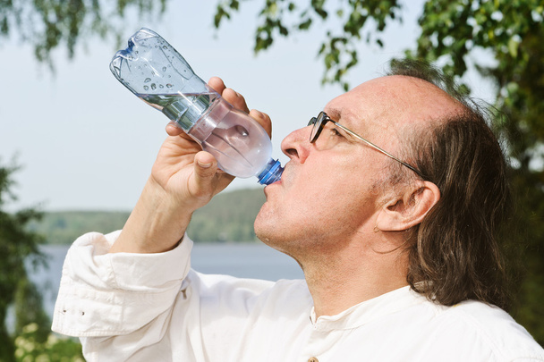 シニア ボトルから水を飲む - 写真・画像