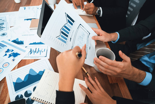 Diverse group of business analyst team analyzing financial data report paper on office table. Chart and graph dashboard by business intelligence analysis for strategic marketing planning Habiliment - Photo, Image