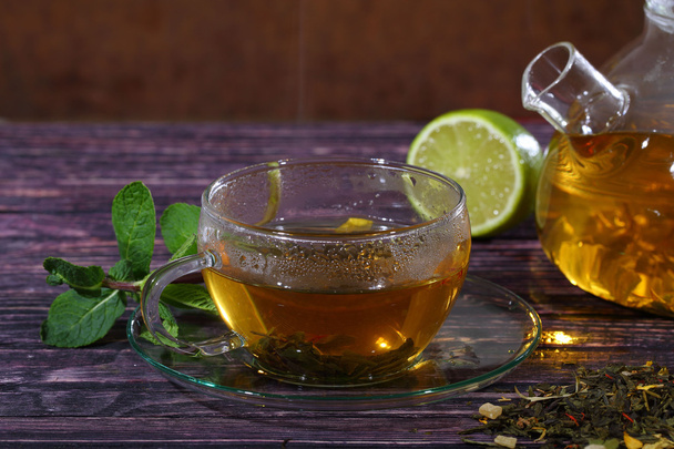 Herbata w szklany czajniczek i przejrzyste filiżanki z cytryna i mięta o - Zdjęcie, obraz