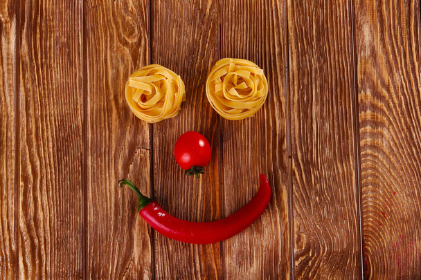  pasta on wooden background with tomato and pepper - Photo, Image