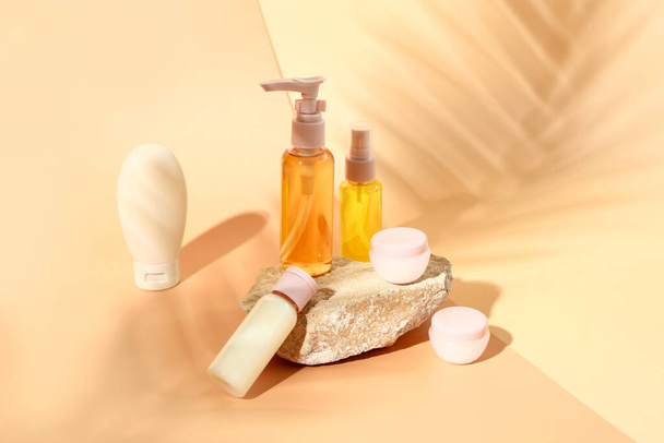 Stone with set of travel cosmetic products on color background - Photo, Image