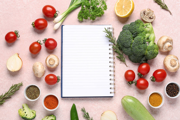 Komposition mit leerem Rezeptbuch, frischem Gemüse und aromatischen Gewürzen auf farbigem Hintergrund - Foto, Bild