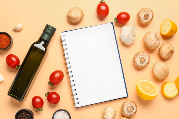 Composición con libro de recetas en blanco, verduras frescas y aceite de oliva sobre fondo de color - Foto, Imagen