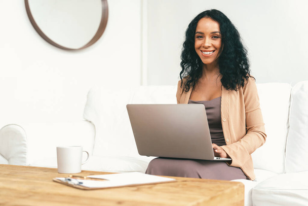 African-American woman using laptop computer for crucial work on internet. Secretary or online content writing working at home. - Valokuva, kuva