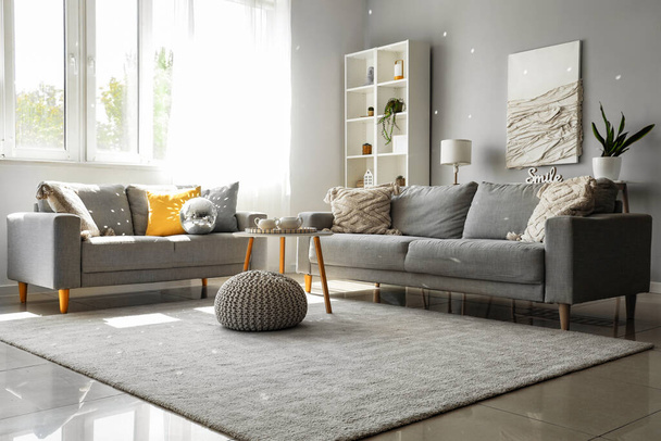Interior de la moderna sala de estar con sofás grises, bola disco y mesa de café - Foto, Imagen