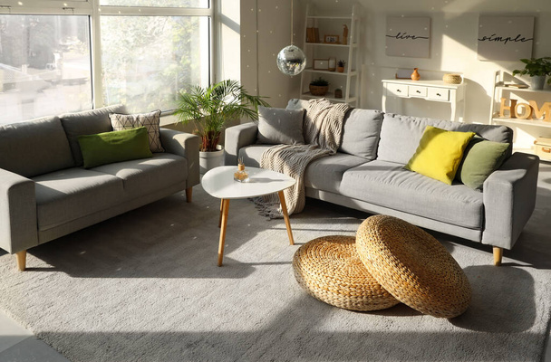 Interiér moderního obývacího pokoje s šedými pohovkami, konferenčním stolkem a visící diskotékou - Fotografie, Obrázek
