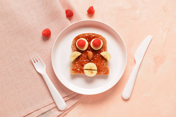 Piatto con divertente colazione per bambini a forma di volto umano sul tavolo rosa - Foto, immagini