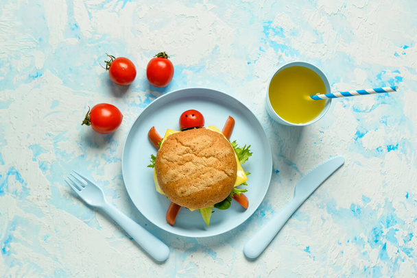 Bord met grappig kinderontbijt in de vorm van schildpad op lichtblauwe tafel - Foto, afbeelding