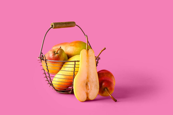 Basket with ripe pears on pink background - Photo, Image
