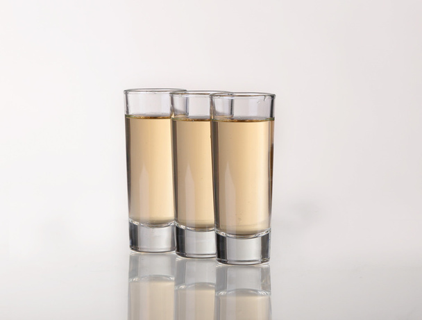 Three gold tequila shots with lime  on white background - Foto, immagini