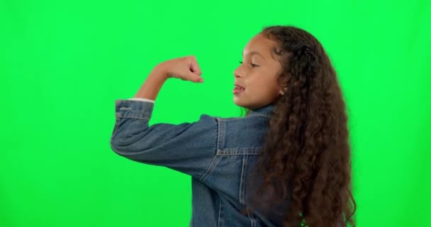 Sterk, gelukkig en een gezicht van een meisje op een groen scherm om spieren, kracht en motivatie te tonen. Glimlach, portret en een jong kind tonen spieren en fitness resultaten geïsoleerd op een studio achtergrond. - Video
