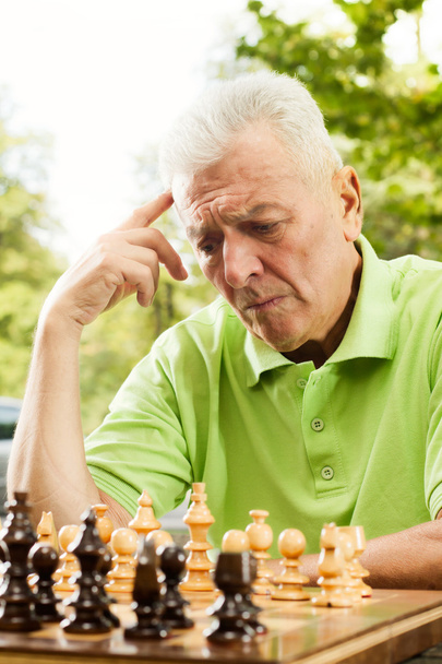 Anciano pensando en los próximos movimientos en el ajedrez
 - Foto, Imagen