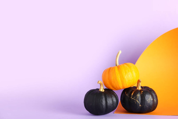 Чорні та помаранчеві гарбузи на кольоровому фоні - Фото, зображення