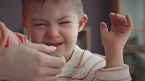 6歳のコーカサス人の男の子のメディアクローズアップダウン症候群は,自宅で泣いている彼の世話をする母親によって慰められています - 映像、動画