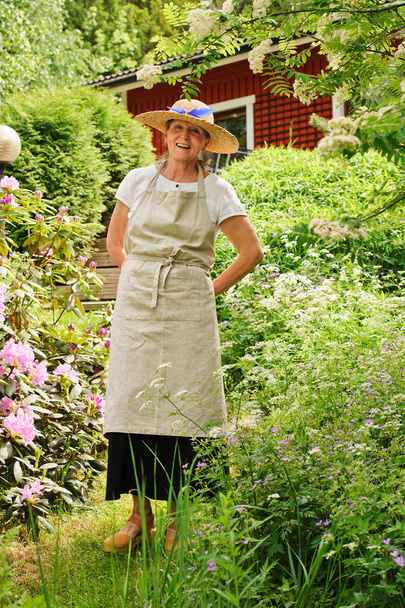 Seniorin steht im Garten - Foto, Bild
