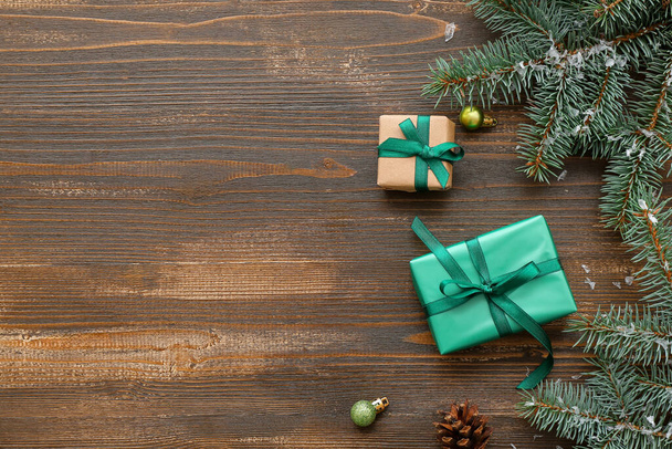 Cajas de regalo con ramas de árbol de Navidad y bolas sobre fondo de madera - Foto, imagen