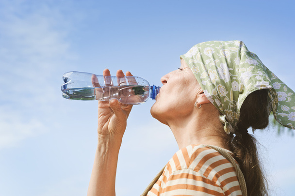 Seniorin trinkt Wasser aus Flasche - Foto, Bild