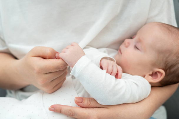 Pasgeboren baby, op een delicaat moment, houdt teder moeders vinger nadruk op een diepe, onuitgesproken verbinding - Foto, afbeelding