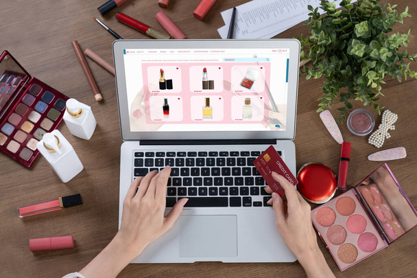 Woman shopping online on internet marketplace browsing for sale items for modern lifestyle and use credit card for online payment from wallet protected by utmost cyber security software - Photo, Image