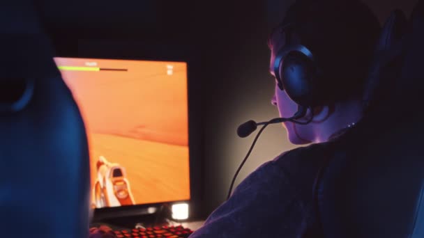 Back view slowmo van verslagen gamer man verliezen in online PC first person shooter spel tijdens het spelen 's nachts in esports club - Video