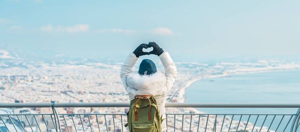 Γυναίκα τουρίστας Επίσκεψη στο Hakodate, Ταξιδιώτης στο Sweater αξιοθέατα θέα από Hakodate βουνό με χιόνι το χειμώνα. ορόσημο και δημοφιλή για τα αξιοθέατα σε Hokkaido, Ιαπωνία. - Φωτογραφία, εικόνα