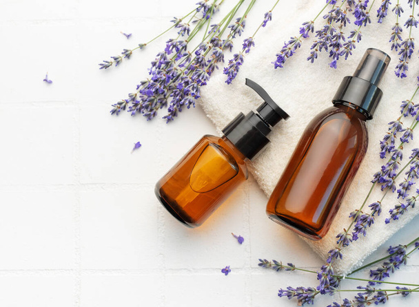 Lavender spa. Lavender  natural essential oil and fresh lavender on a white tile background. - Photo, Image
