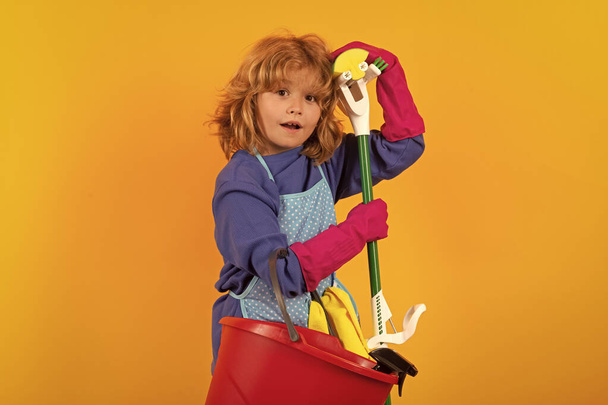 Прибирання будинку. Студійний ізольований портрет дитячого будинку, прибирання будинку. Мийні засоби та засоби для чищення. Служба прибирання. Маленький хлопчик смішний домогосподарка
 - Фото, зображення