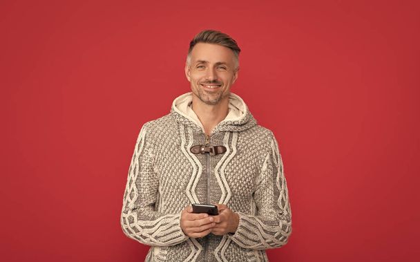 щасливий красивий чоловік одягнений светр тримає телефон, сучасне життя
. - Фото, зображення