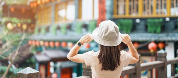 viajera mujer visitando en Taiwán, Turista con sombrero de turismo en Jiufen Old Street pueblo con fondo Tea House. atracciones históricas y populares cerca de la ciudad de Taipei. Concepto de viajes y vacaciones - Foto, imagen