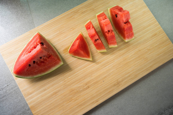 Horní pohled plátek melounu na dřevěné desce v kuchyni - Fotografie, Obrázek