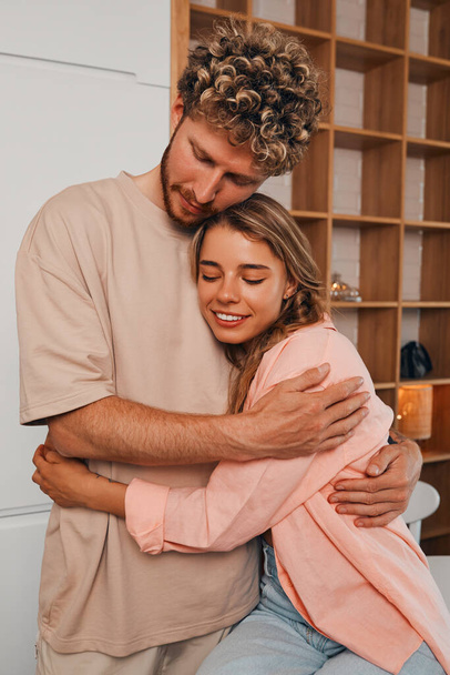 Young love, beautiful, married couple, hugging and having fun in the kitchen, cooking breakfast together at home, spending the weekend romantically. - Foto, Imagem