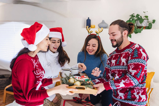 Amigos latinos horneando y degustando galletas navideñas en casa juntos en México América Latina - Foto, imagen