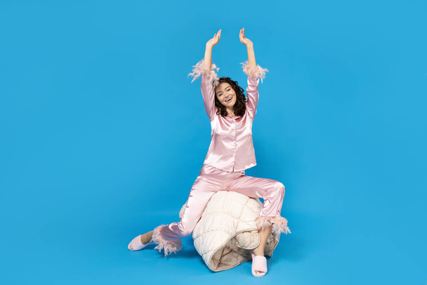 Девушка в розовой пижаме на синем фоне. - Фото, изображение