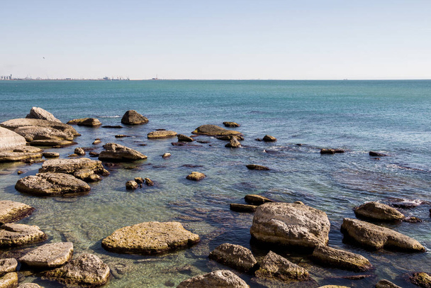 Βραχώδης ακτή της Κασπίας Θάλασσας. Μεγάλες πέτρες στην ακτή. Ένα θεϊκό μέρος. Ανάπλαση της Κασπίας Θάλασσας στην πόλη Aktau. - Φωτογραφία, εικόνα