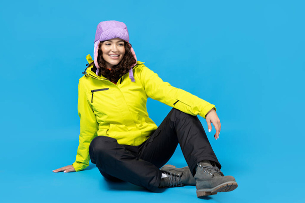 Mavi arka planda, kayak takımlı bir kız.. - Fotoğraf, Görsel