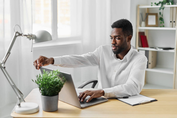человек работа офис образования онлайн киберпространство американского расстояния в помещении сидя африканский человек связи фрилансер бизнес черный компьютер ноутбук глядя с помощью студента улыбается - Фото, изображение