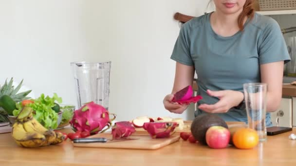 Ázsiai nő készít zöldség gyümölcs kevert ital a bőr és az egészség edzés után az egészség otthon. étrend és egészséges étel koncepció. - Felvétel, videó