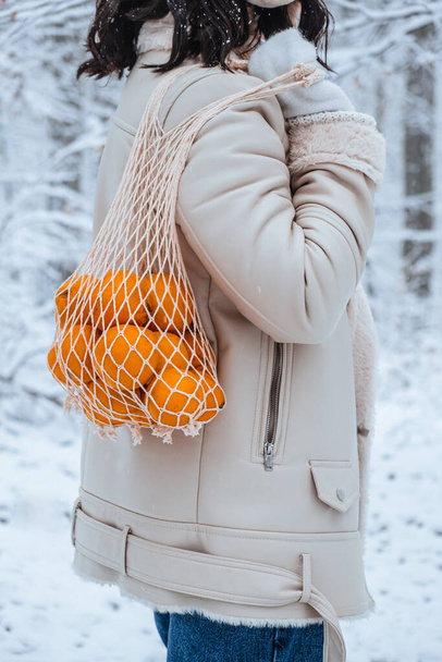 pessoa segura saco de vime com tangerinas - Foto, Imagem