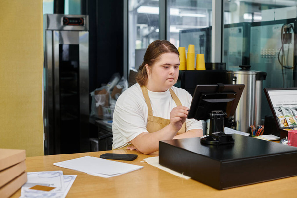 dipendente femminile attento con disturbo mentale funzionamento terminale di cassa mentre si lavora in caffè moderno - Foto, immagini
