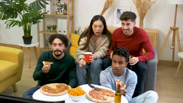 Group of friends eating pizza and celebrate their soccer team score goal in a shared student house. - Footage, Video