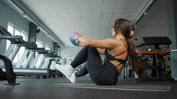 Красивая сильная мускулистая женщина занимается спортом в тренажерном зале - Кадры, видео