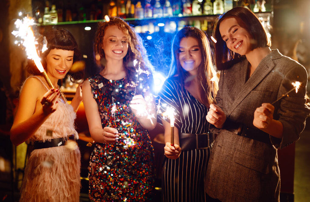 Three young Woman with champagne glasses at night club. Women friends drinking champagne in the bar. - Foto, imagen
