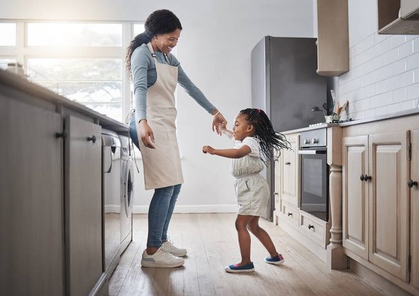 Creo que mi madre es increíble. una niña y su madre bailando en la cocina en casa - Foto, Imagen