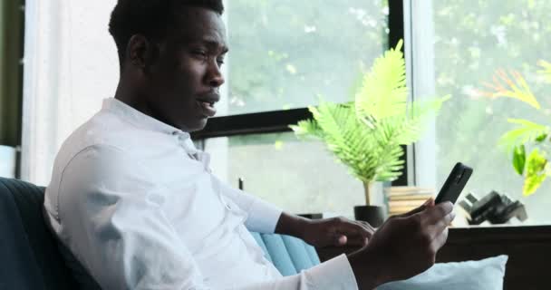 Een portret vangt een Afro-Amerikaanse man op in een videogesprek. Zijn expressieve trekken en geëngageerde houding benadrukken de essentie van moderne virtuele communicatie. - Video