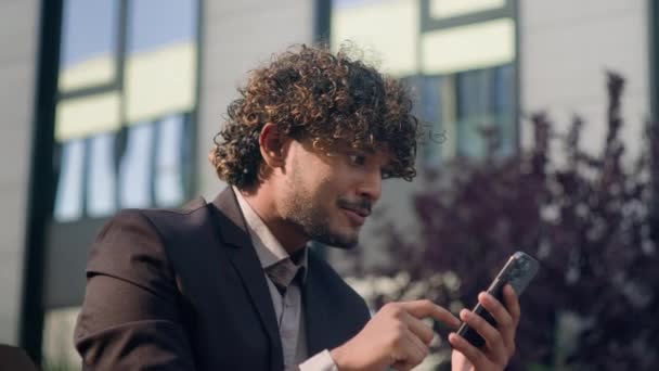 Hispanique heureux excité étonné homme d'affaires indien se réjouir de la réussite gagnante de téléphone mobile célébrer la victoire en ligne offrir un bon résultat prix sms message opportunité Arabe gagnant homme d'affaires en ville - Séquence, vidéo