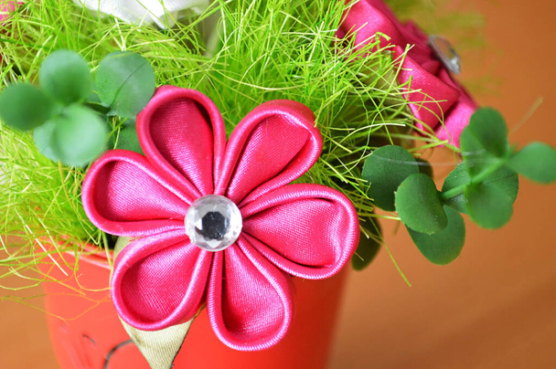 Flor de tela rosa hecha a mano (kanzashi). Decoración floral artificial. Concepto de hobby y artesanía. - Foto, imagen