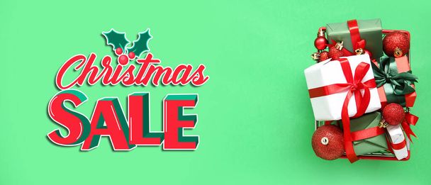 Winkelwagen met geschenken en tekst CHRISTMAS SALE op groene achtergrond - Foto, afbeelding