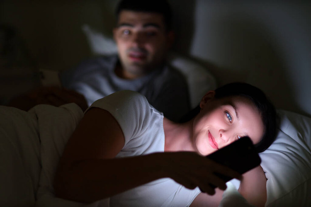 Mladá žena pomocí mobilního telefonu v ložnici v noci, detailní záběr - Fotografie, Obrázek