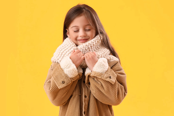 Petite fille en vêtements d'hiver sur fond jaune - Photo, image